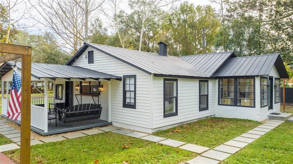 Side of the home showcasing the porch swing and patio with pergola