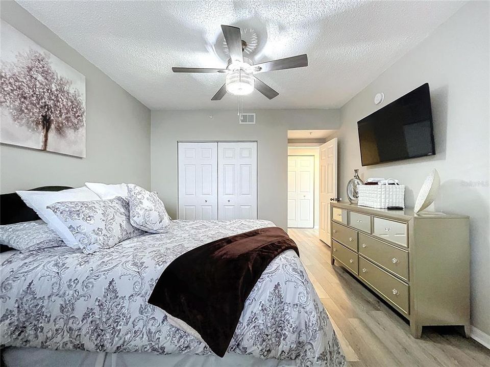 The second bedroom offers privacy from the living space and access to the guest bathroom and in-unit laundry in the hallway.