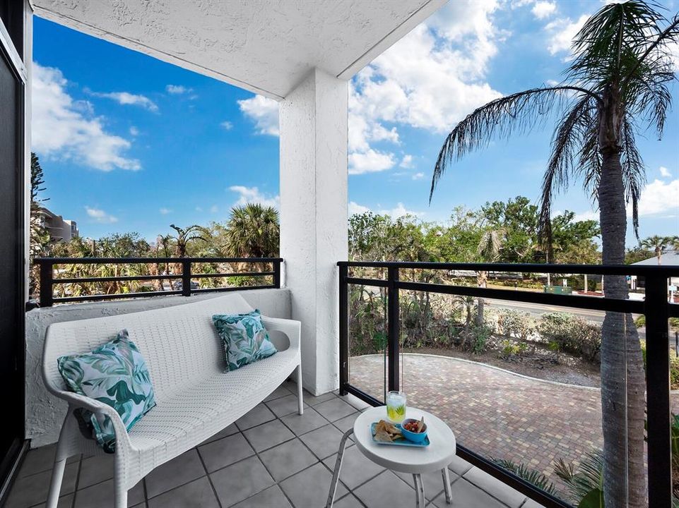 This balcony surrounded by lush palm trees, faces east for ideal sunrise views and serves as a peaceful extension of the owner's suite.