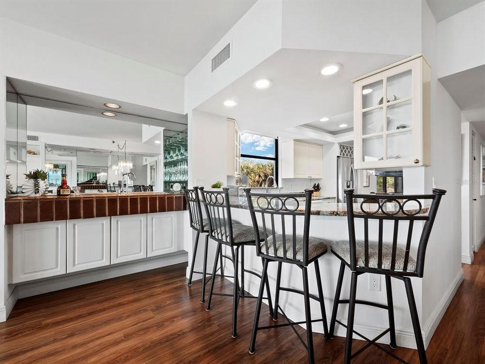 The wet bar also features recessed lighting, a mirrored wall, shelving for glassware, as well as cabinets below to house your spirits.