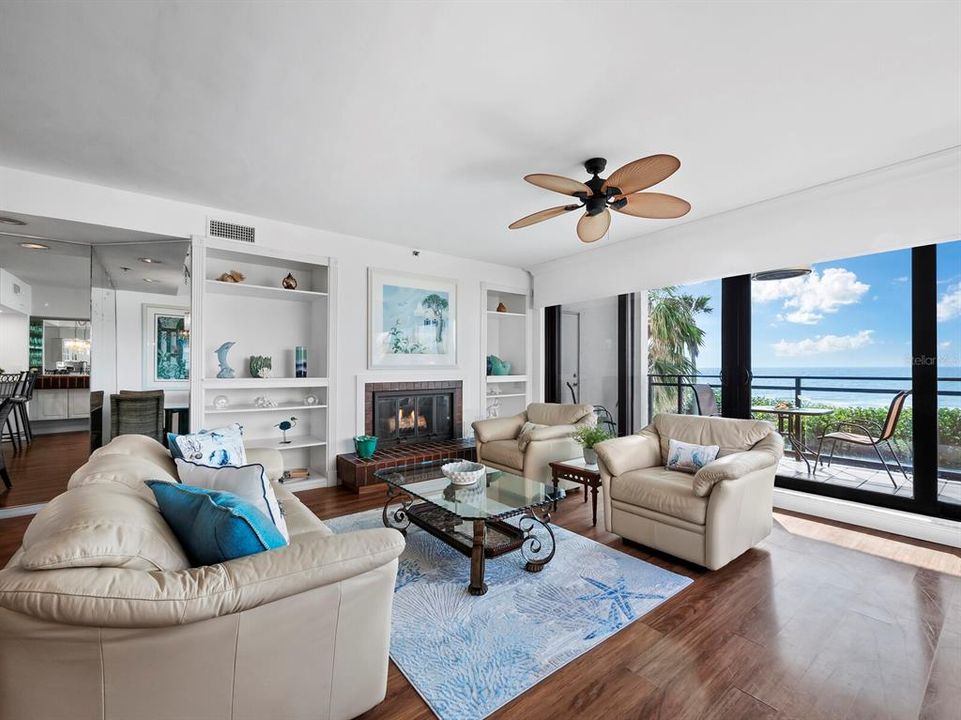 Stunning views of the Gulf of Mexico through large sliding glass doors and built-in shelving with a cozy fire place, create an inviting and relaxing space for you, your family, and guests alike.