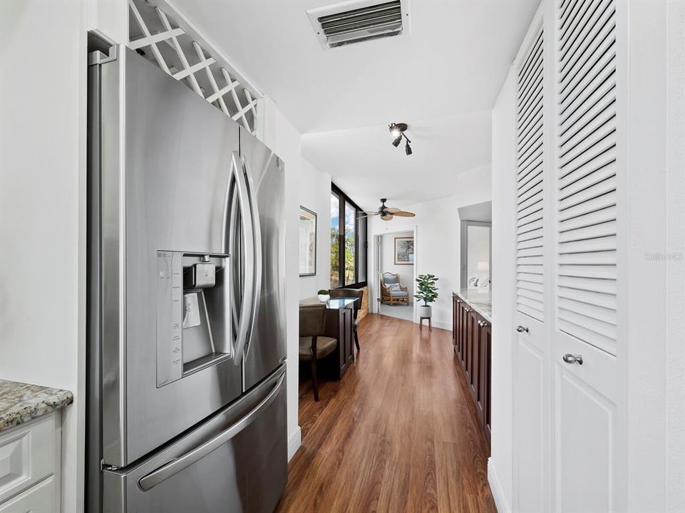 Enjoy ample storage options, including a built-in wine rack above the fridge, a pantry closet, and a dry bar featuring abundant cabinetry with convenient pull-out drawers.