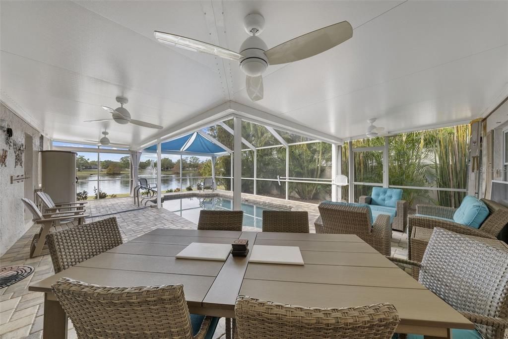 This photo shows the extended covered area by the pool, which has a view of the pond. The covered area is a great place to relax and enjoy the view.