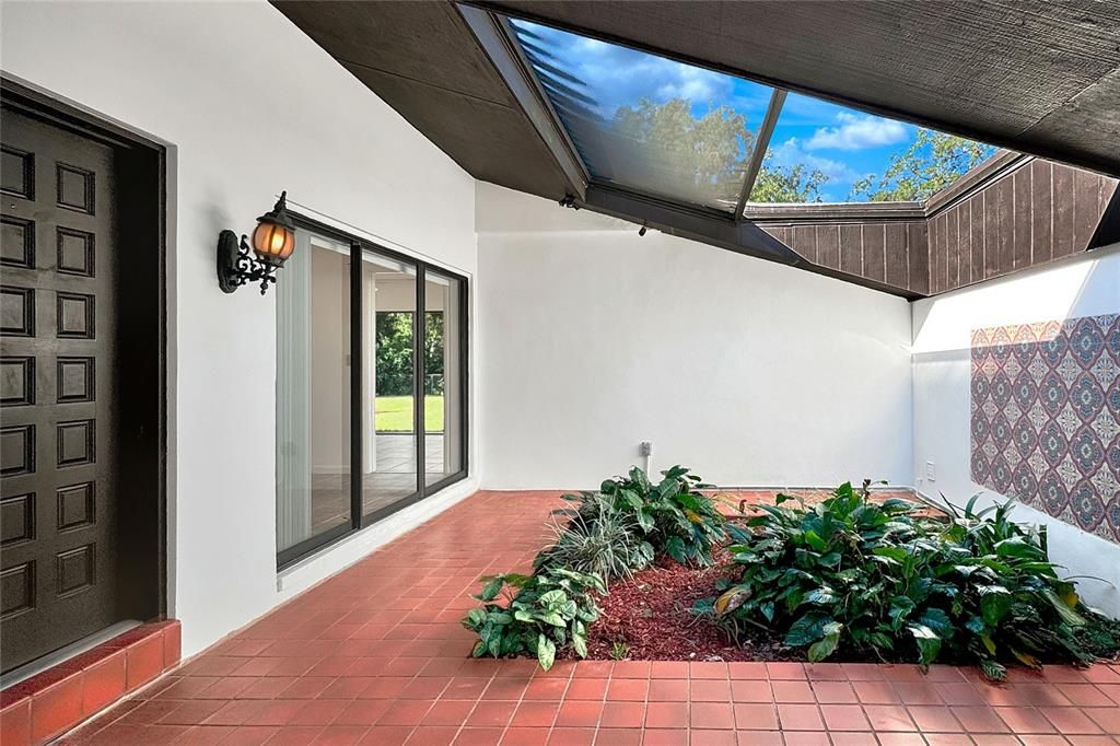 More mediterranean decor in tiled mural, viewed through sliders in dining room. Notice the view into the back yard?