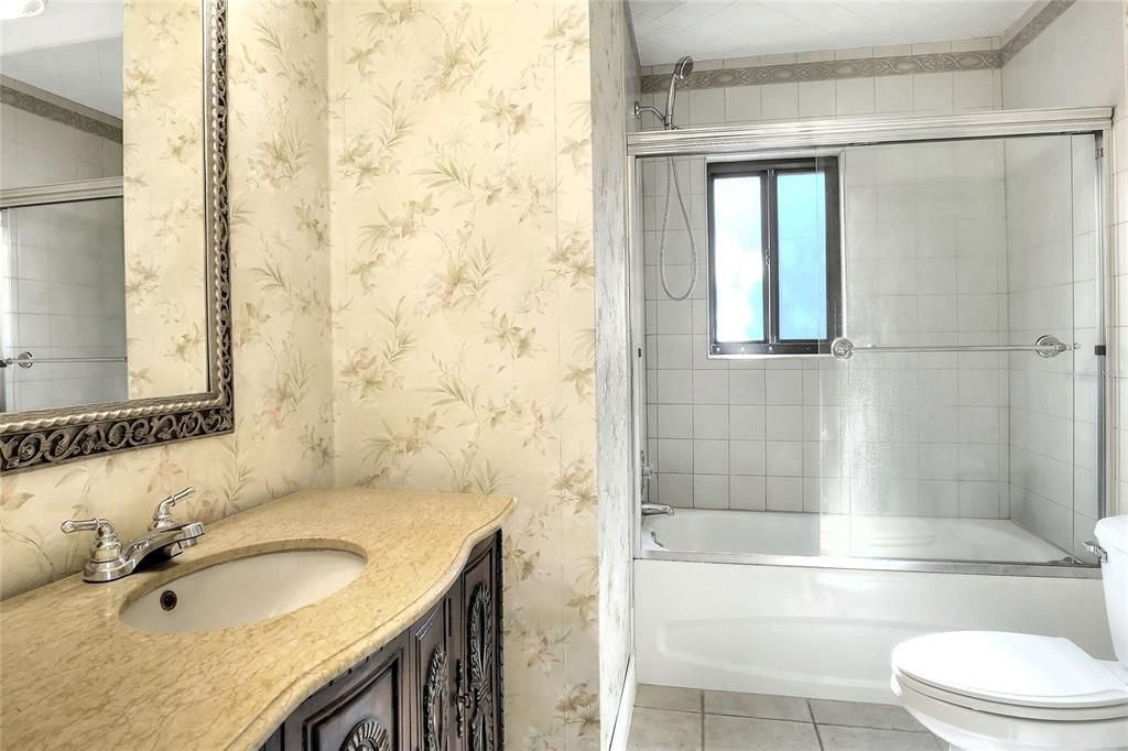 Shared hall bath between 2nd and 3rd bedrooms has an ample linen closet behind the door