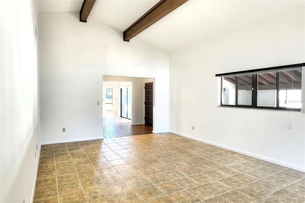 Well-lit view from living room through dining room, eat-in kitchen, clear into backyard.