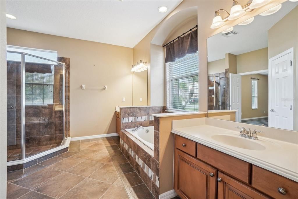 Primary bath room includes double sink vanities, garden tub and walk in shower