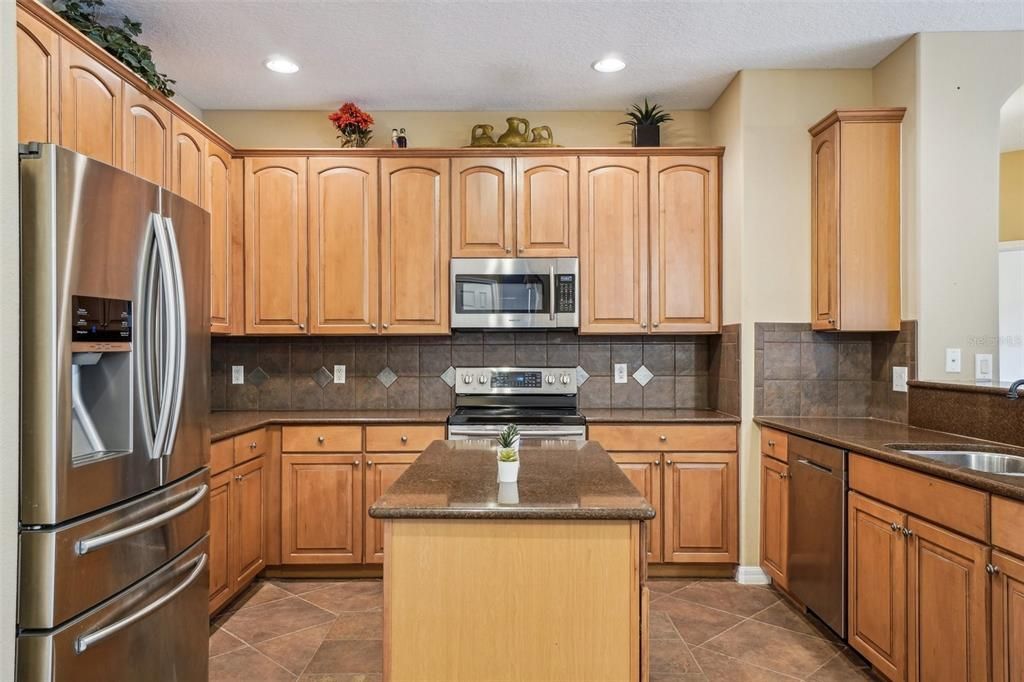 Kitchen features a center island, granite counters, and stainless steel appliances