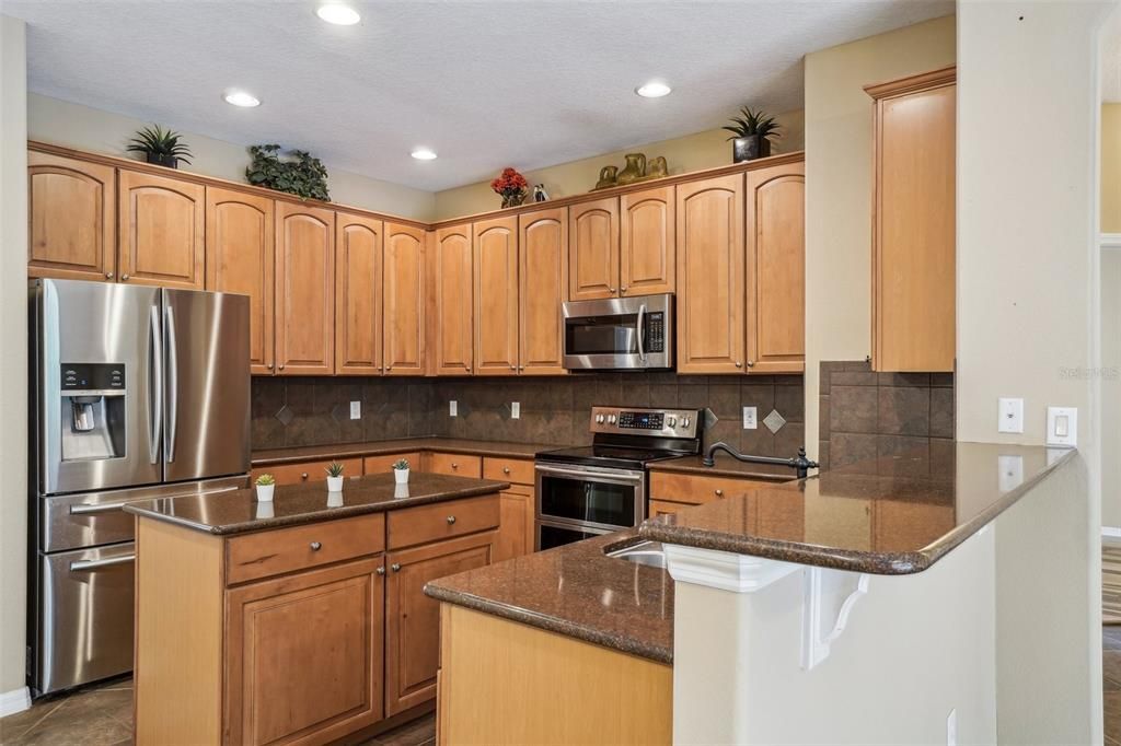 Kitchen has an abundance of storage space and a breakfast bar