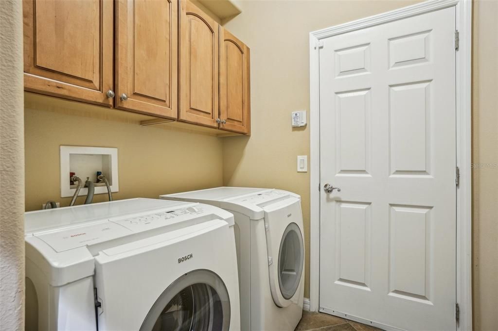 Laundry room off the garage with storage cabinets