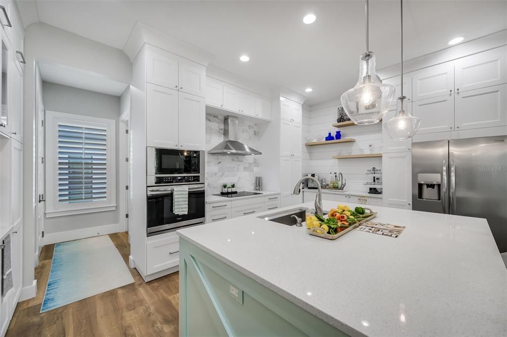 view shows european open shelving, custom hood and wet bar area