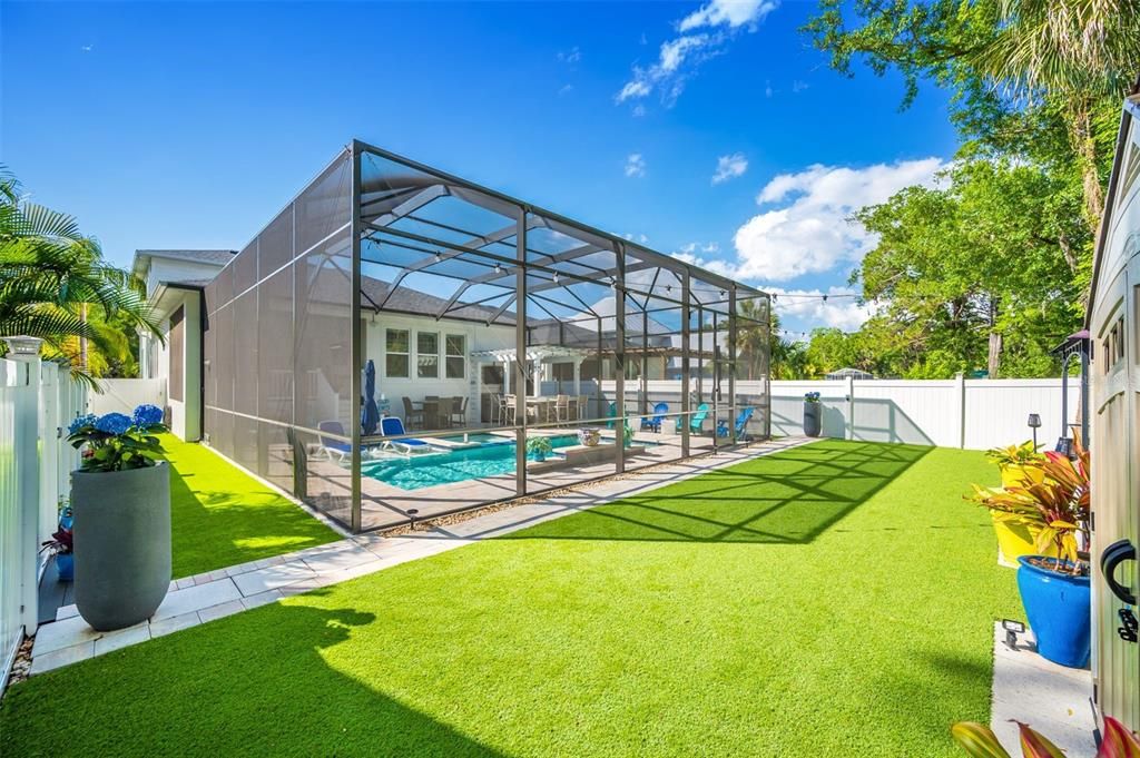 outdoor area behind pool has artificial grass with surrounding drainage system.  Pet friendly