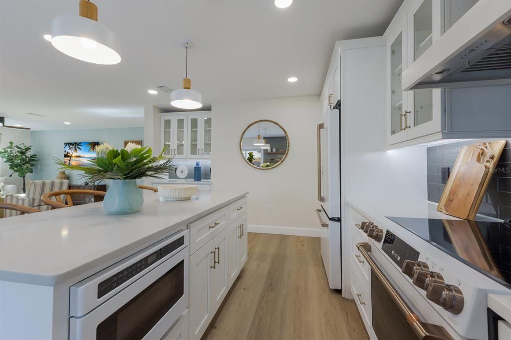 Gorgeous quartz counter tops on kitchen island offering built in microwave