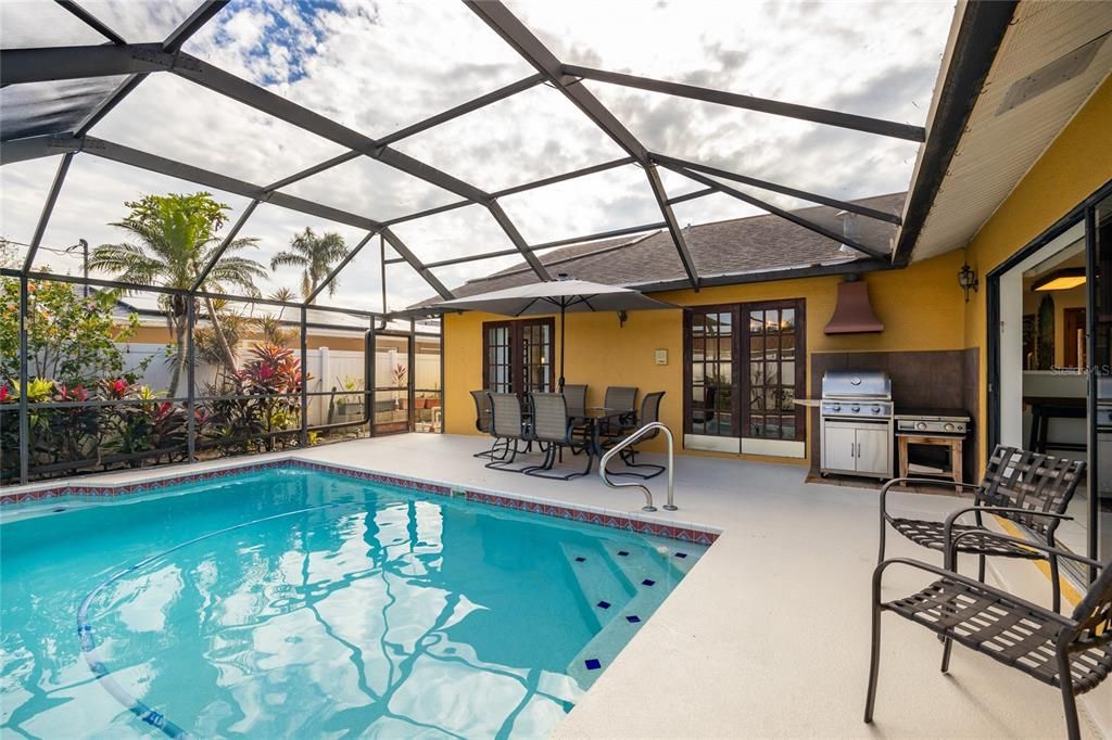 French doors from the primary bedroom and dining room as well as pocketing sliding doors provide access to this pool and lanai.