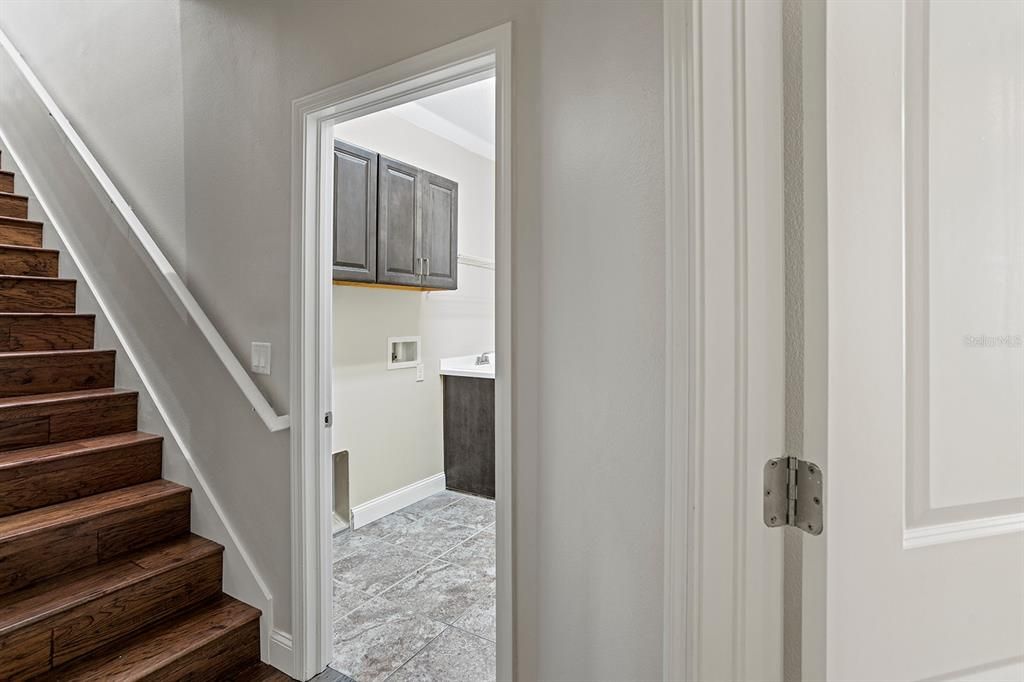 View of laundry room and stairs