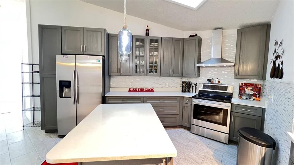 Great custom made cabinetry with stainless steel appliances and exhaust fan.