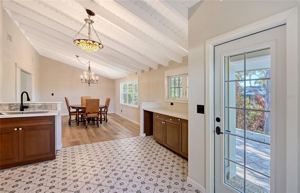 Kitchen with Serving Counter, All Wood Cabinetry, Corian Solid Surface Countertop, Room for Bar Refrigerator, Tile Floor, New Window and Door, Open to Dining Room.