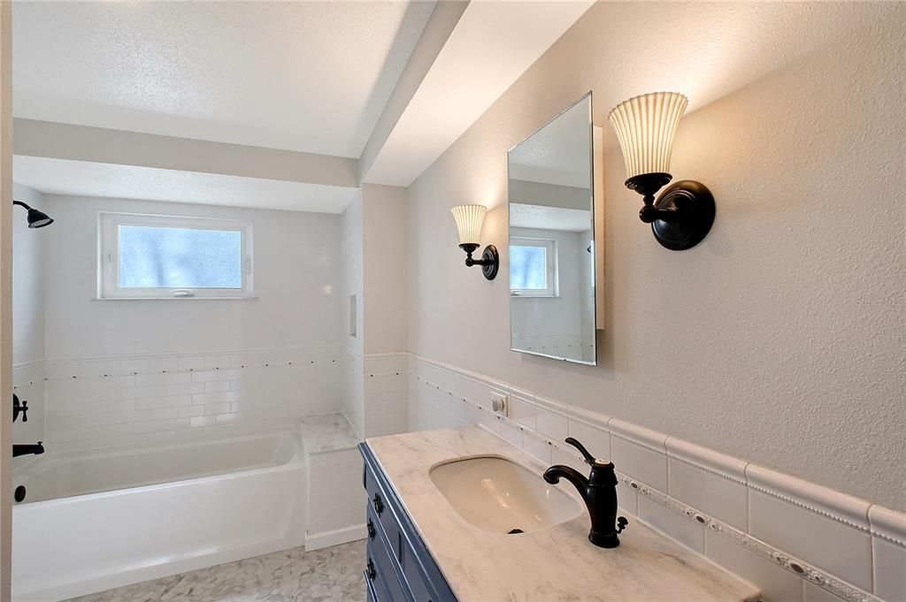 Bath #2 Single Vanity Sink with Corian Solid Surface Countertop, Porcelain Tile Flooring, Deep Tub