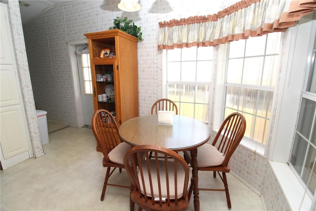 Dinette area in the Kitchen that leads to the laundry room to the back left and there is a back door leading out to your oversized yard.