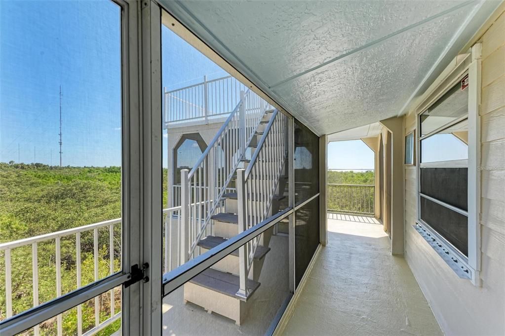 First floor screened room views of water and additional stairs to widows walk