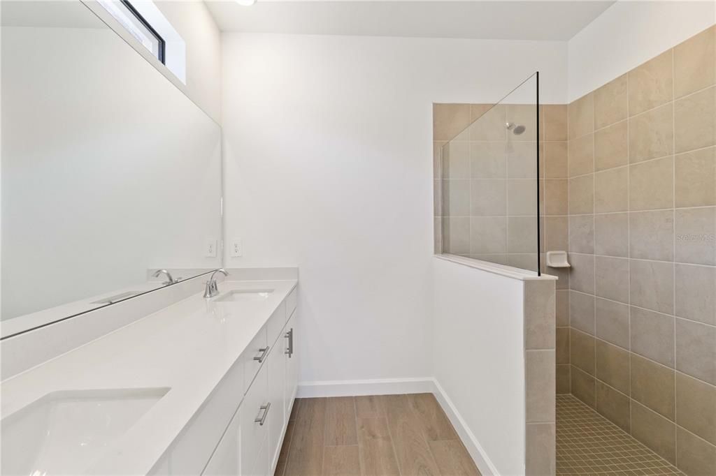 Ensuite Owners Bath with standup shower, dual sinks, and watercloset