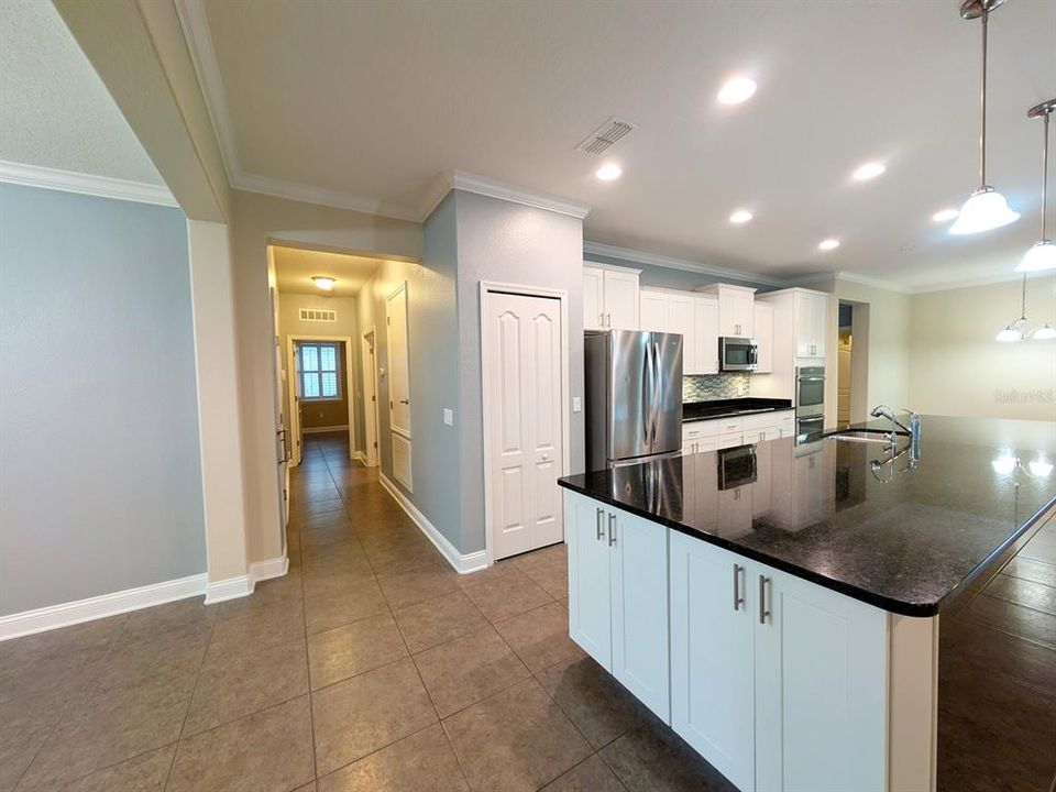 View down other hallway leading to garage and bedroom 2, en-suite bathroom, separated from other bedrooms