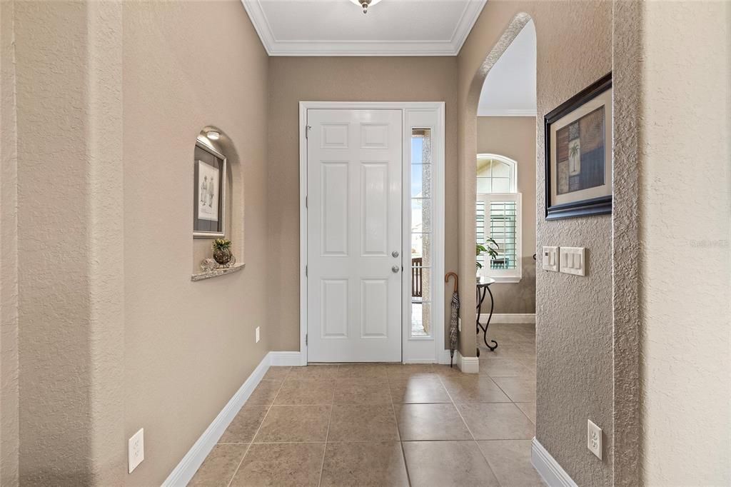 Foyer with tile, crown molding 5.25" baseboards, kitchen to right of door