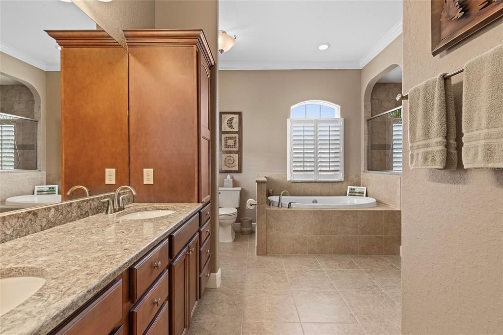 Quartz countertops with dual sinks, large luxury soaking tub, plantation shutters