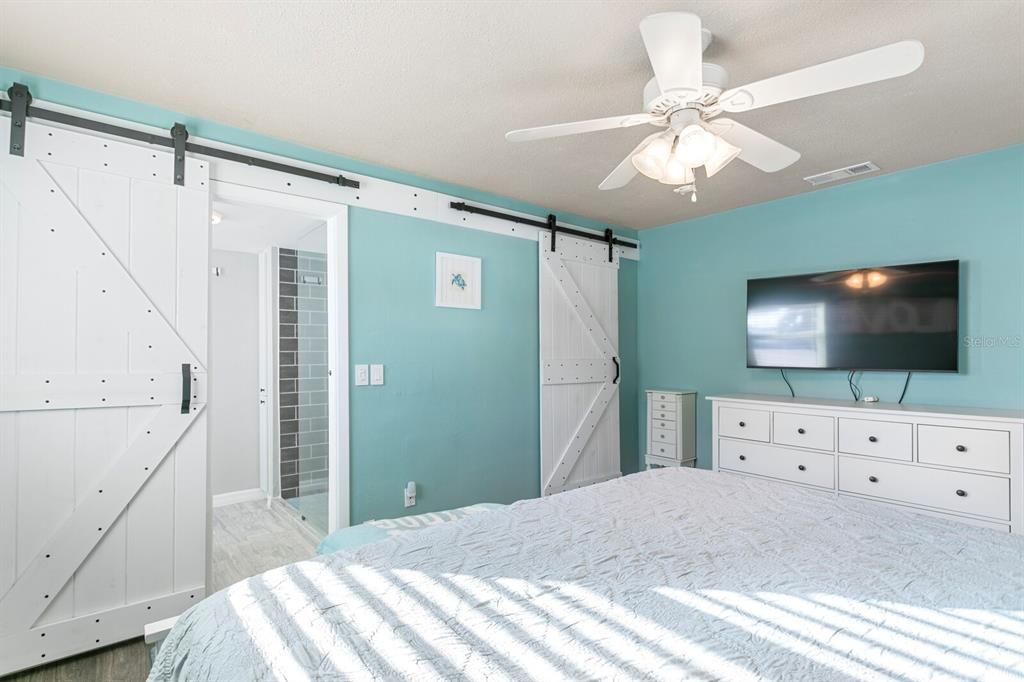 Custom barn doors and walk-in-closet in primary suite