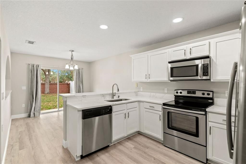 Fully remodeled kitchen features quartz countertop and stainless steel appliances