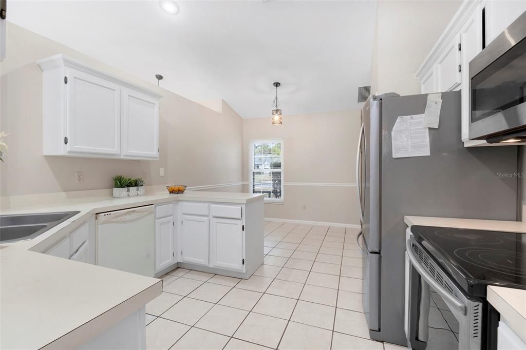 eat-in kitchen with classic wooden cabinets painted white for a clean and bright look