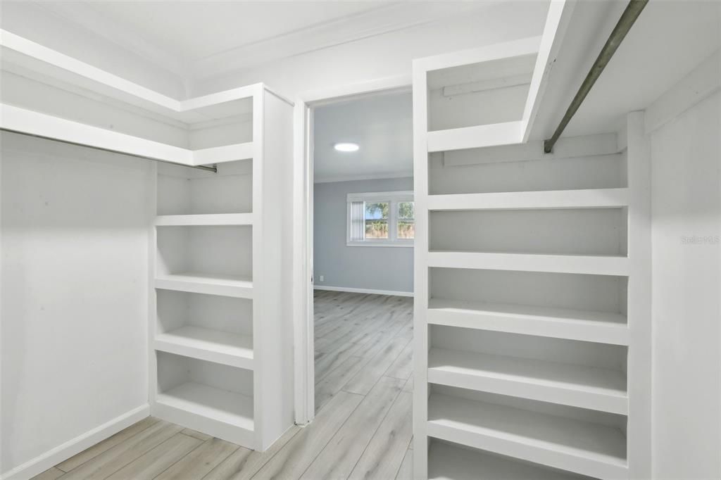 Primary Bedroom Walk In Closet with custom storage shelving