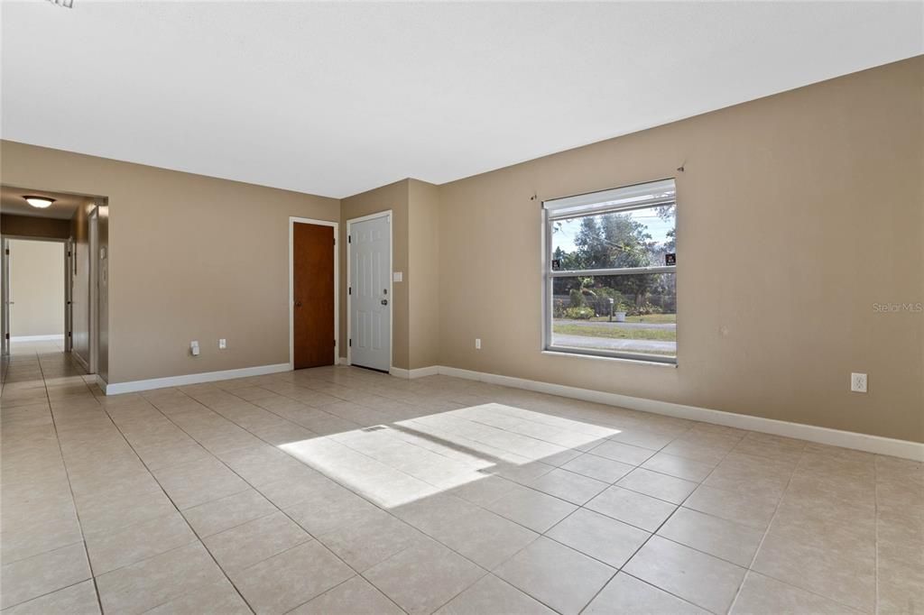 Living Room with front door in center and hall to bedrooms to the left.