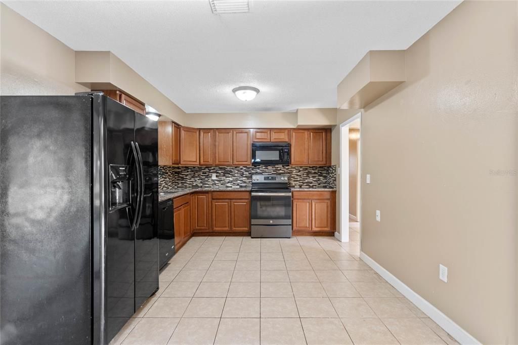 Kitchen with granite counters and eat-in space to right