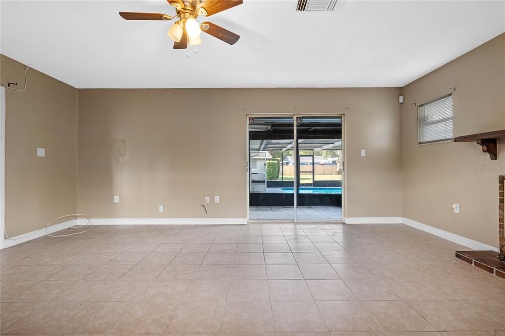 Master bedroom with fireplace to the right and sliders out to the pool area.