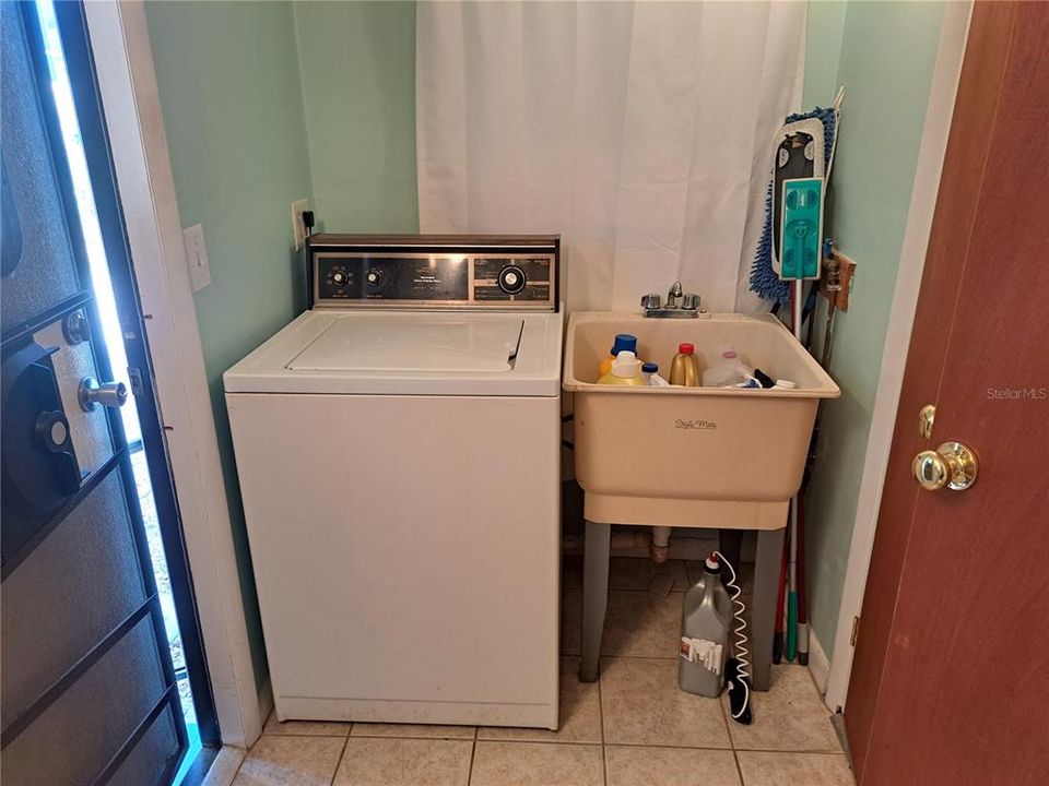 Washer & sink at other end of bathroom. Dryer in the shed. Exit to yard on left.