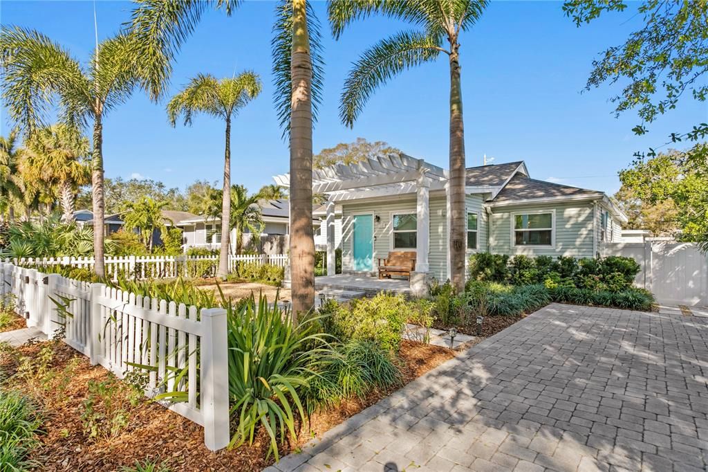 Inviting paver driveway and lush landscaping