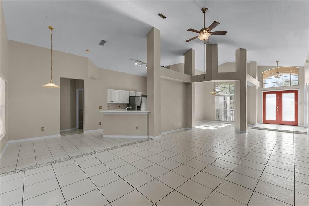 Living room with kitchen nook on left and dining room to right