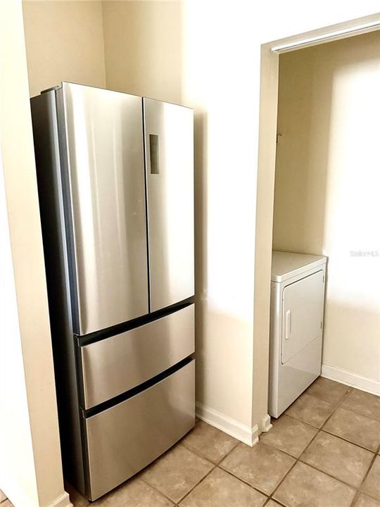 Newer Refrigerator Adjacent to the Laundry Room