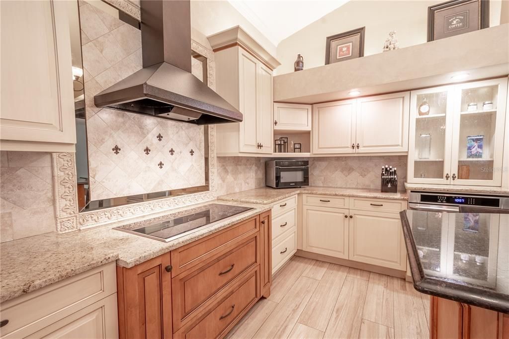 The kitchen features soft-close solid wood cabinets and drawers, granite countertops and a stylish tile backsplash.