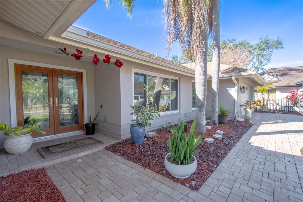 Brick paver drive and walkway, covered entry, double French doors with beveled glass.