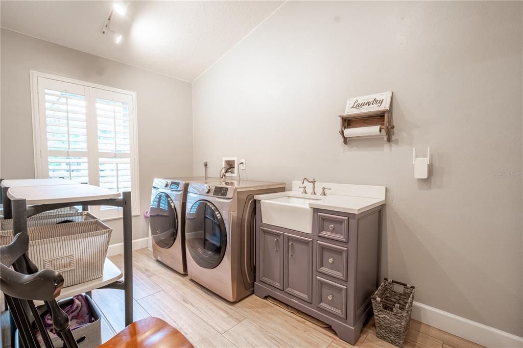 The laundry room with stylish porcelain farm sink and cabinet.