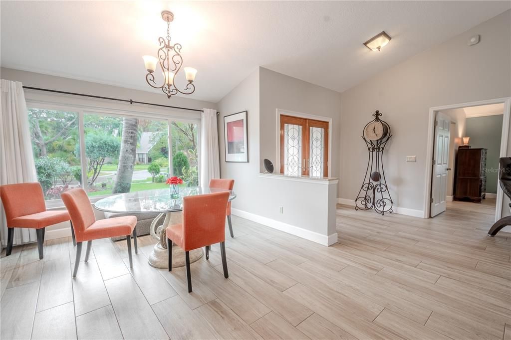 The dining room features a three-globe chandelier and a stunning picture window.