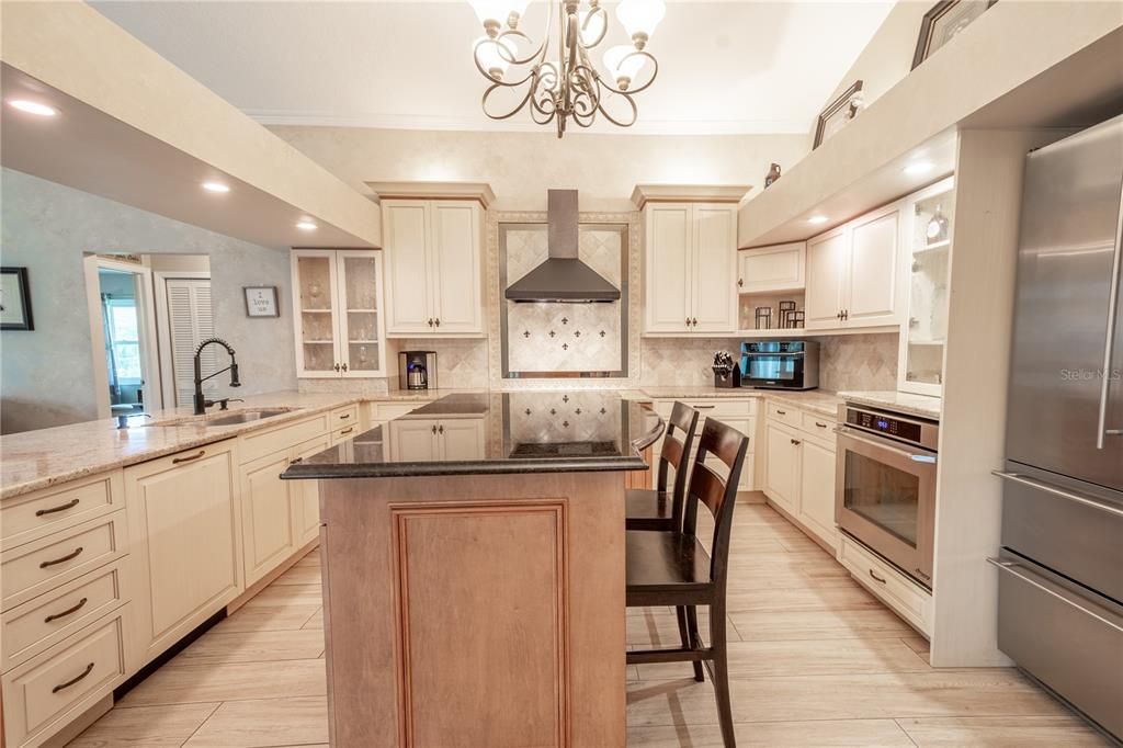 In the center of the kitchen is an solid wood island with a granite countertop, additional storage and seating.