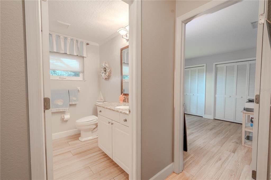 Bathroom 2 features a mirrored vanity with storage and a stone counter, and a tub with shower.