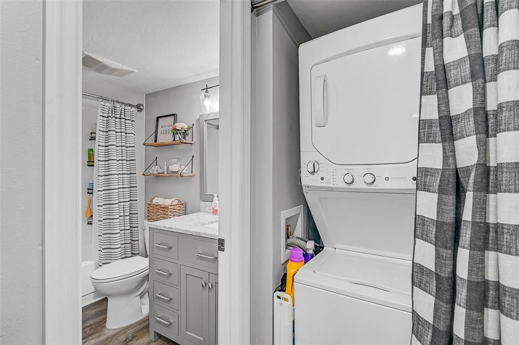 The stackable washer and dryer are conveniently tucked away in the hallway, maximizing functionality and space.