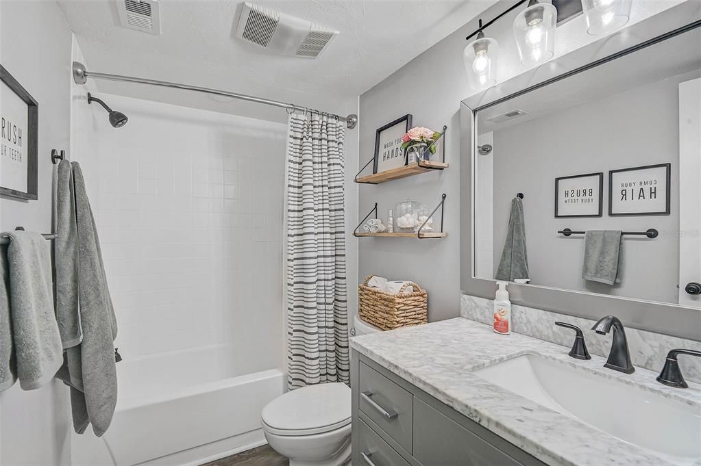 Beautifully updated bathroom featuring a tub and shower combination, offering both style and practicality.