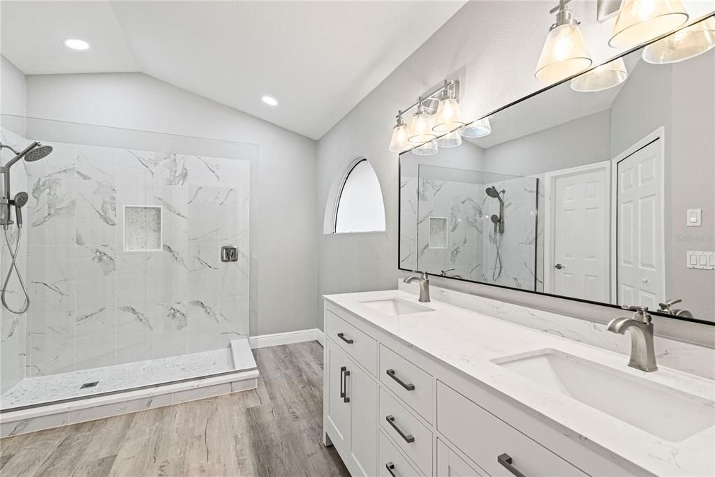 Luxurious Master Bath has been completely redesigned featuring a double quartz top vanity, custom designed glass walk-in shower and spacious walk-in closet.