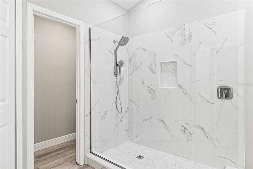 Luxurious Master Bath has been completely redesigned featuring a double quartz top vanity, custom designed glass walk-in shower and spacious walk-in closet.