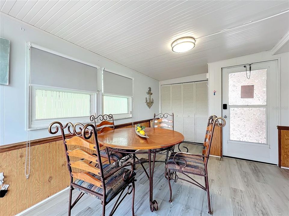 Dining room with vinyl plank flooring throughout, except for tile in the bathroom.  Closet in the back has the stackable washer and dryer.